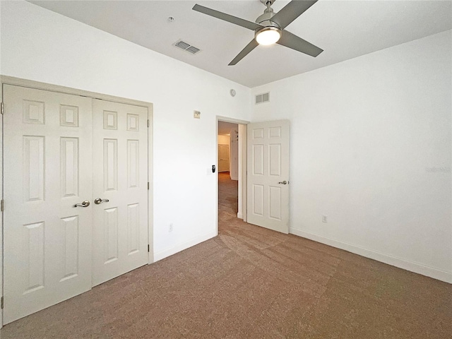 unfurnished bedroom with a closet, ceiling fan, and carpet floors