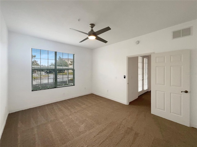 carpeted spare room featuring ceiling fan