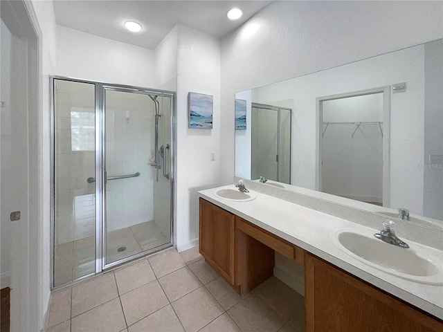 bathroom with walk in shower, vanity, and tile patterned flooring