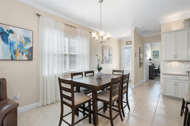 tiled dining space featuring ornamental molding and a chandelier