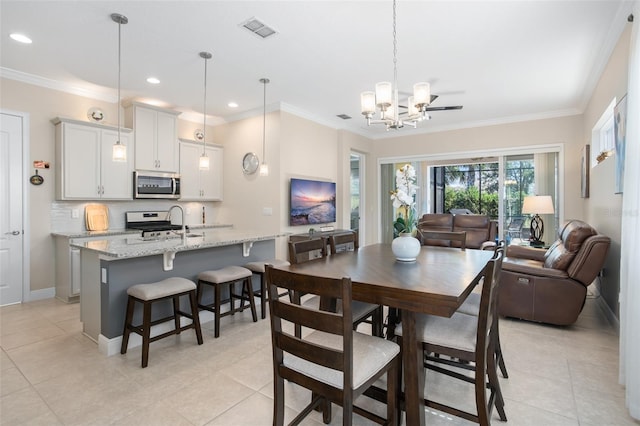 dining space with ornamental molding, light tile patterned floors, and a chandelier