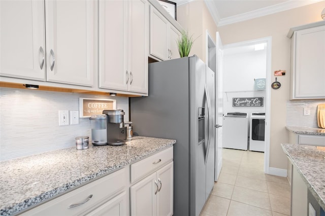 kitchen with white cabinetry, washer and dryer, light tile patterned floors, ornamental molding, and light stone countertops