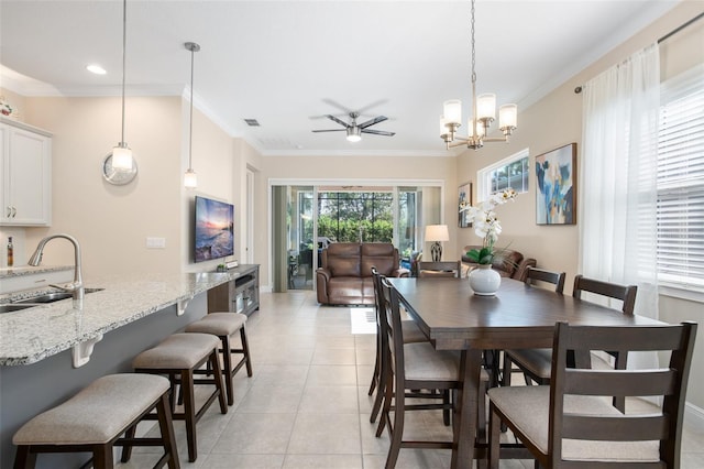 dining area with crown molding, ceiling fan, sink, and light tile patterned floors