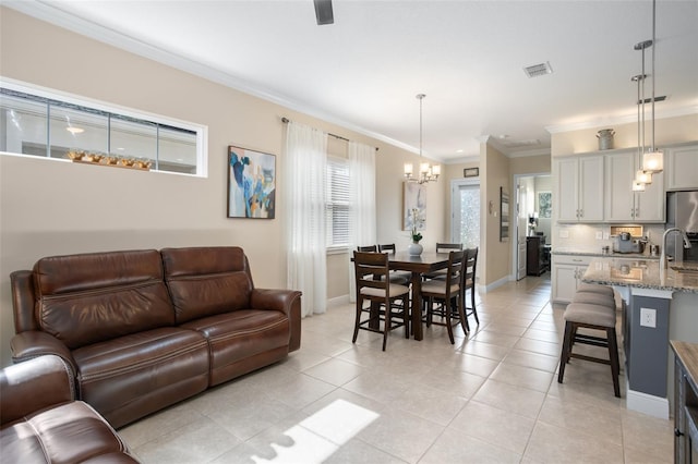 living room featuring a notable chandelier, crown molding, sink, and light tile patterned flooring