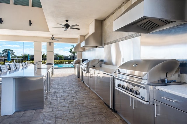 view of patio / terrace featuring a grill, area for grilling, ceiling fan, and a bar