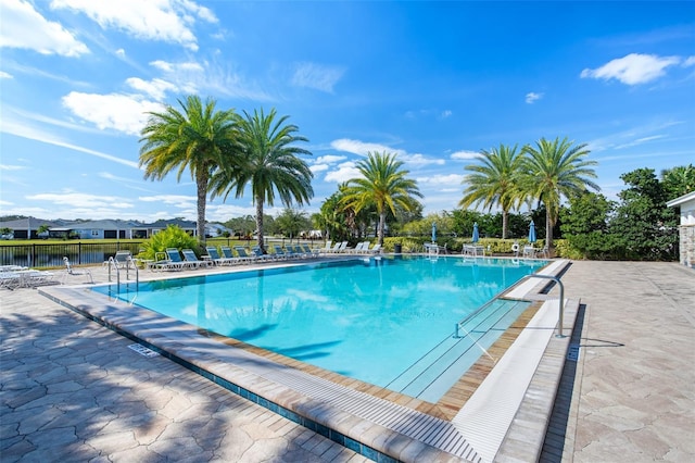 view of swimming pool featuring a patio area and a water view