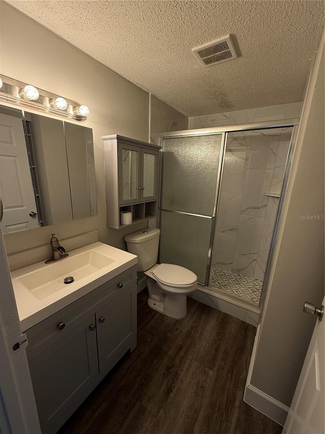 bathroom featuring walk in shower, lofted ceiling, a textured ceiling, vanity, and hardwood / wood-style flooring