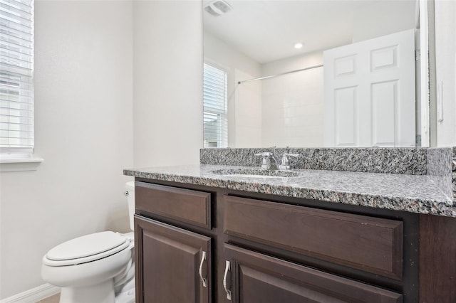 bathroom featuring a shower, toilet, and vanity