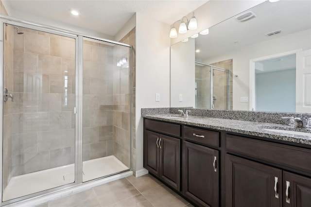 bathroom featuring an enclosed shower, tile patterned floors, and vanity