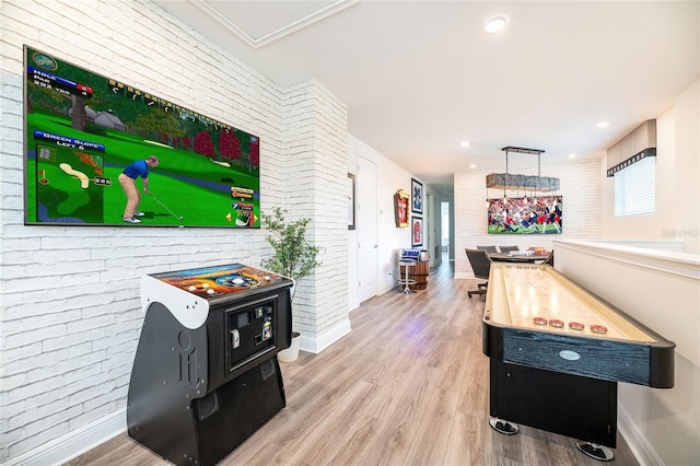 game room featuring wood-type flooring and brick wall