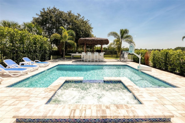 view of swimming pool with an in ground hot tub, an outdoor bar, and a patio area