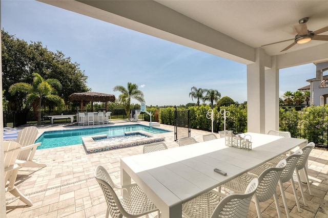 view of swimming pool with ceiling fan, a bar, an in ground hot tub, and a patio