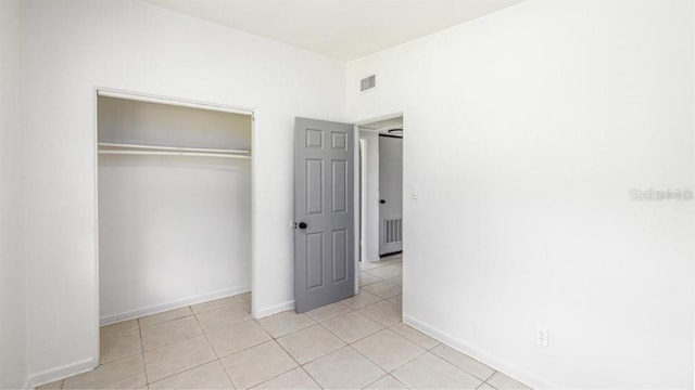 unfurnished bedroom featuring a closet and light tile patterned flooring