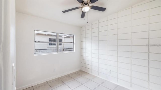 tiled spare room featuring ceiling fan