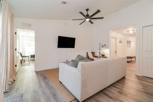 living room with lofted ceiling, light hardwood / wood-style floors, and ceiling fan