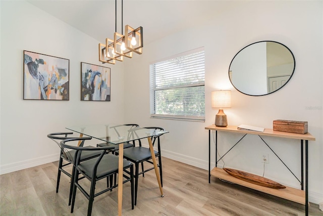 dining area with a notable chandelier and light hardwood / wood-style floors