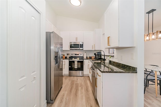 kitchen featuring stainless steel appliances, white cabinetry, sink, and pendant lighting