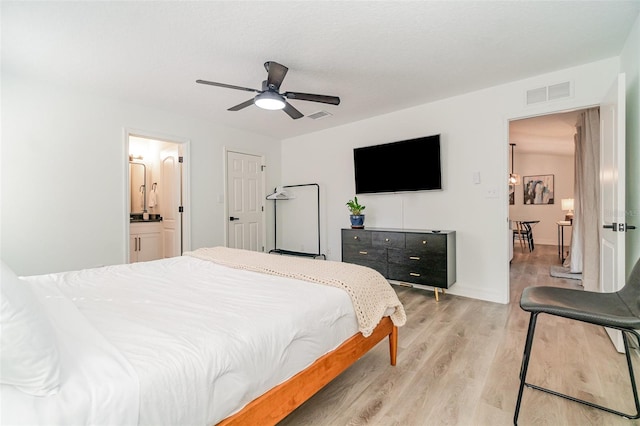 bedroom with connected bathroom, ceiling fan, and light hardwood / wood-style floors