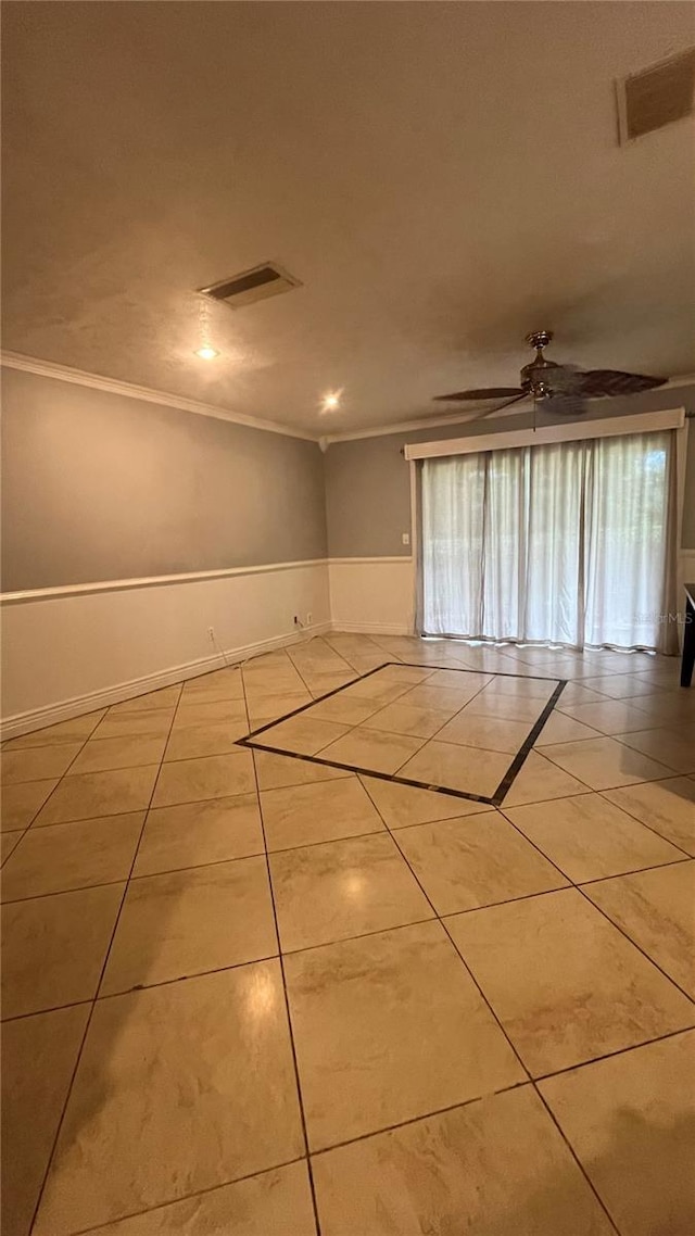 tiled spare room with crown molding and ceiling fan