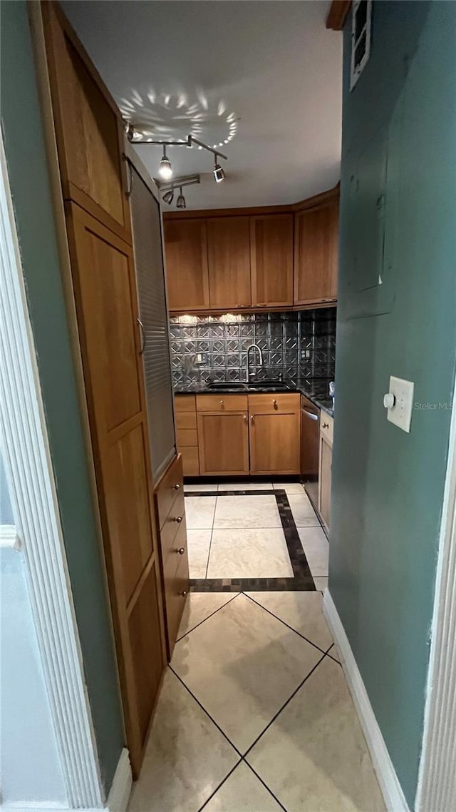 kitchen with tasteful backsplash, dishwasher, sink, and light tile patterned floors