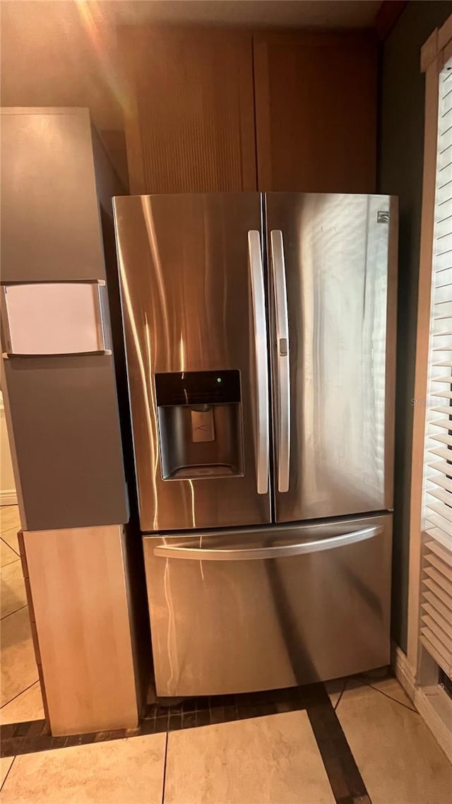 kitchen with stainless steel fridge with ice dispenser and light tile patterned floors