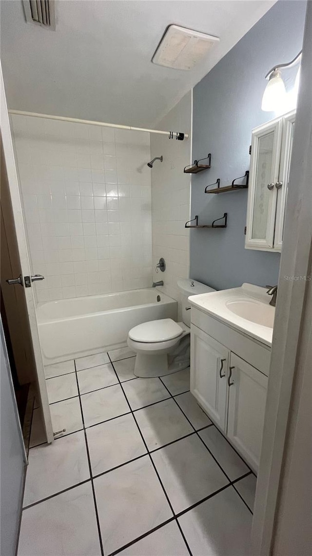 full bathroom featuring vanity, tile patterned flooring, tiled shower / bath combo, and toilet