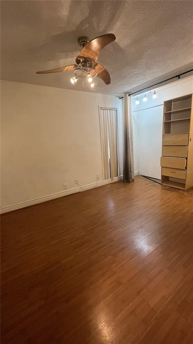 empty room featuring hardwood / wood-style flooring, ceiling fan, and a textured ceiling