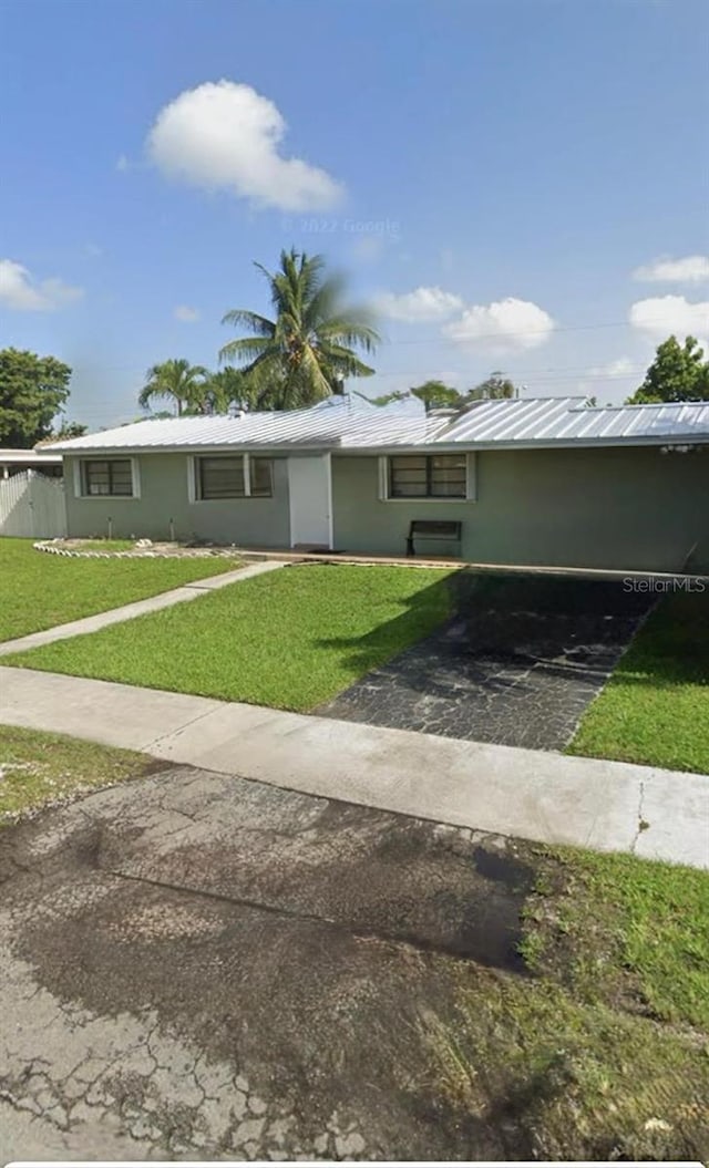 ranch-style house featuring a front lawn and a carport