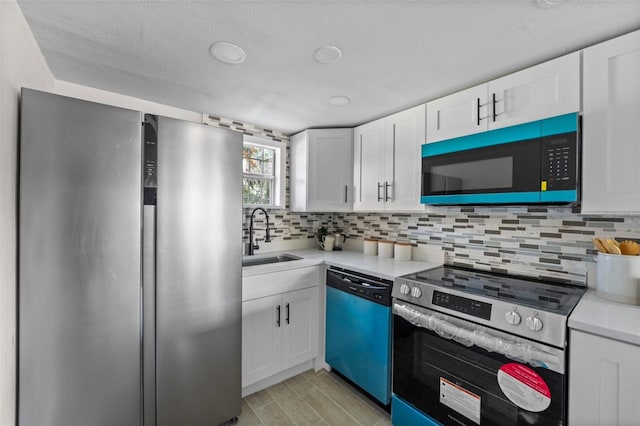 kitchen with sink, white cabinetry, decorative backsplash, and stainless steel appliances