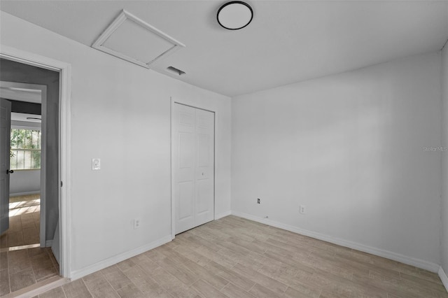 unfurnished bedroom featuring light hardwood / wood-style floors and a closet