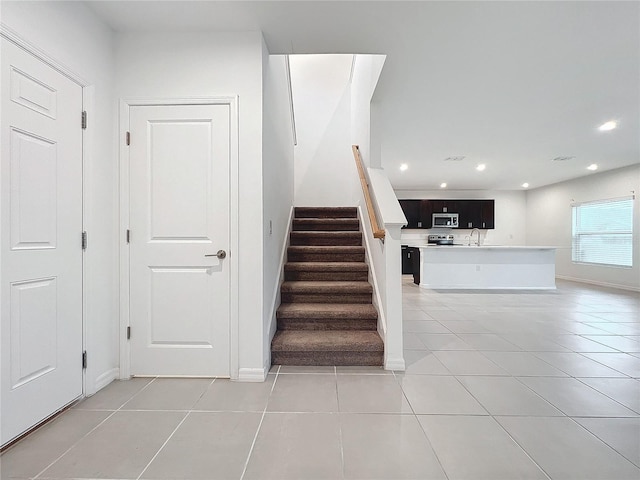 staircase featuring sink and tile patterned flooring