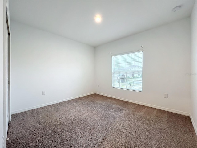 unfurnished room with dark carpet