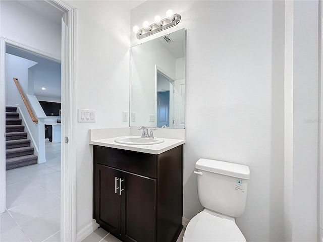 bathroom featuring toilet, vanity, and tile patterned flooring