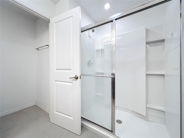 bathroom with tile patterned floors and a shower with door