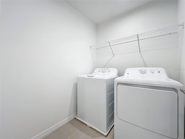 washroom featuring light tile patterned floors and washer and clothes dryer