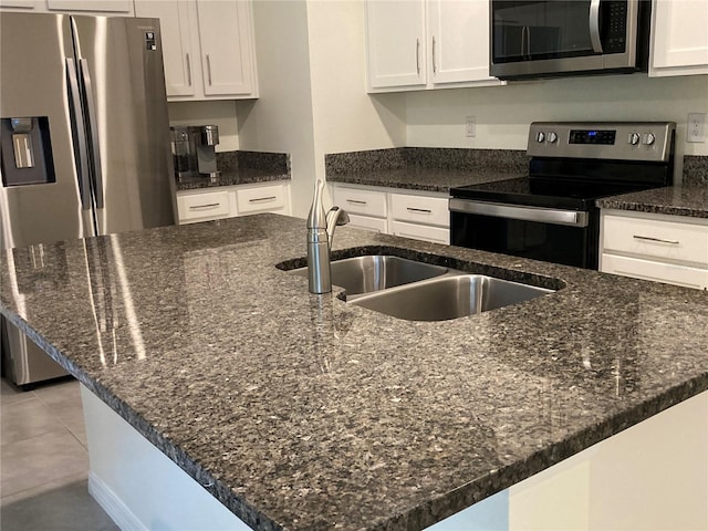 kitchen with dark stone countertops, appliances with stainless steel finishes, and white cabinets