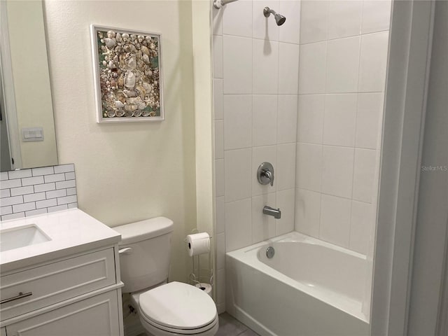 full bathroom featuring tiled shower / bath, vanity, toilet, and backsplash