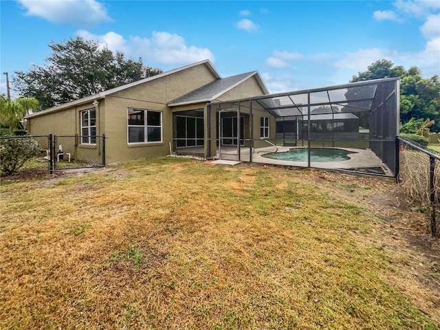 rear view of house with a patio area, a lanai, and a lawn