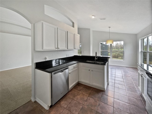 kitchen with sink, white cabinets, stainless steel dishwasher, and dark carpet