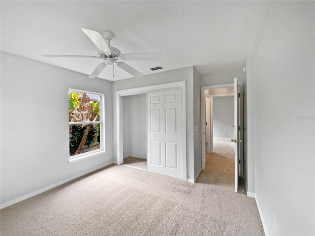 unfurnished bedroom featuring a closet, ceiling fan, and light colored carpet