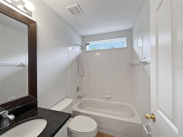 full bathroom featuring vanity, bathing tub / shower combination, a textured ceiling, and toilet