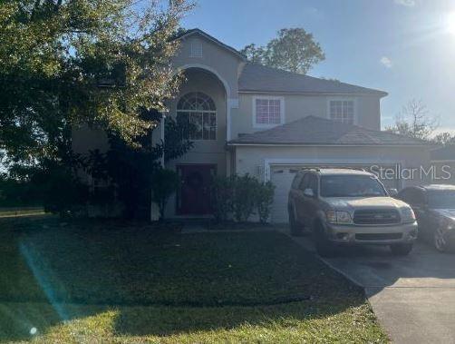 view of front of house featuring a garage and a front lawn