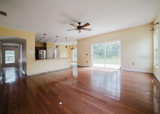 1010 Embrun Ct, Kissimmee, FL 34759 - unfurnished living room with ceiling fan, visible vents, dark wood-style floors, and a healthy amount of sunlight