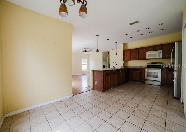 1010 Embrun Ct, Kissimmee, FL 34759 - kitchen featuring visible vents, a sink, a peninsula, open floor plan, and stainless steel appliances