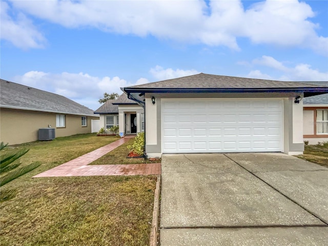 view of front of house featuring cooling unit, a garage, and a front lawn