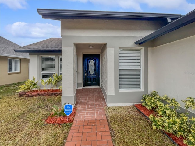 entrance to property with a lawn