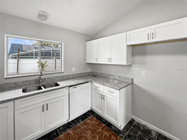 kitchen with sink, white cabinets, vaulted ceiling, and dishwasher