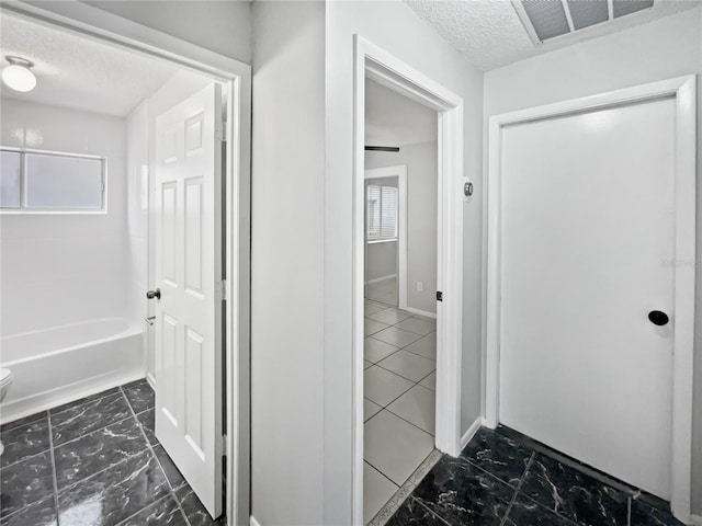 bathroom with toilet and a textured ceiling