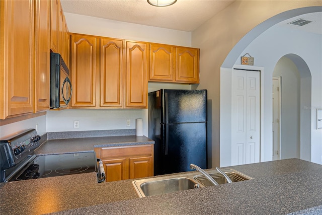 kitchen featuring black appliances, a textured ceiling, and sink