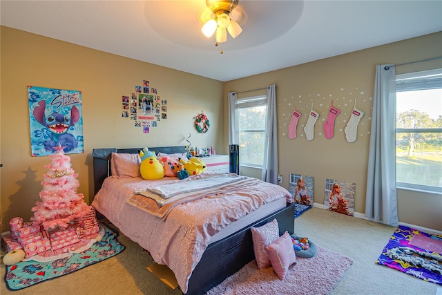 carpeted bedroom featuring ceiling fan and multiple windows